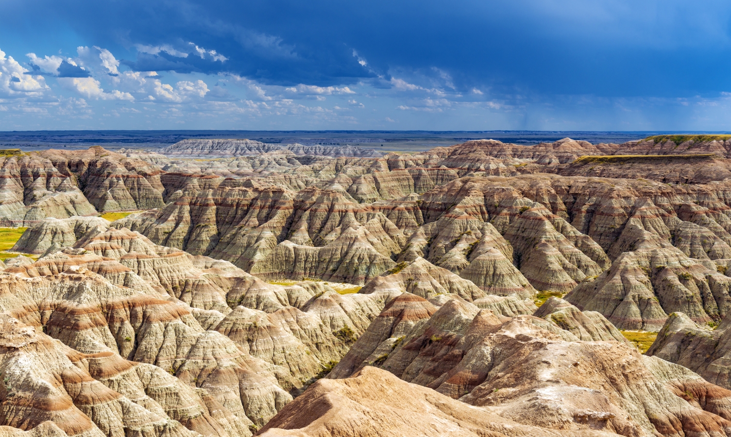 A thunderstorm inside Badlands national park with the rock formations illuminated by sunlight near Rapid City, South Dakota, USA.